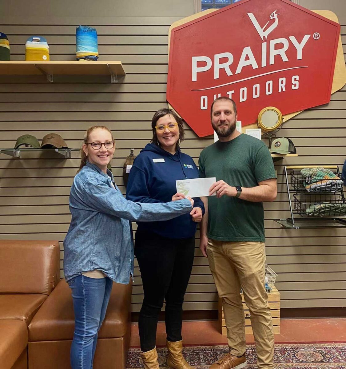 Aaron and Hannah Gaeddert presenting a check to Libby Albers, Assistant Director of the Kansas Alliance for Wetlands and Streams